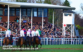 The Grandstand at Taunton Racecourse with a horse race taking place