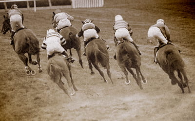 A vintage picture of horses running across the terrain at Newmarket