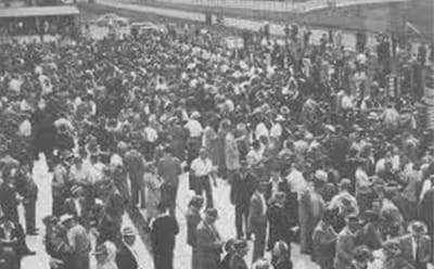 A vintage crowd at Sandown Park Racecourse in black and white