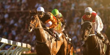 three horses racing on a track