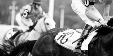 A black & white picture of two horses racing.