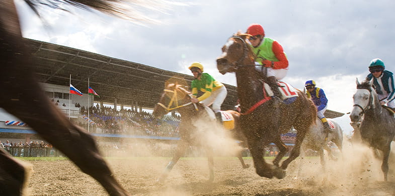 Horses racing on a sand track